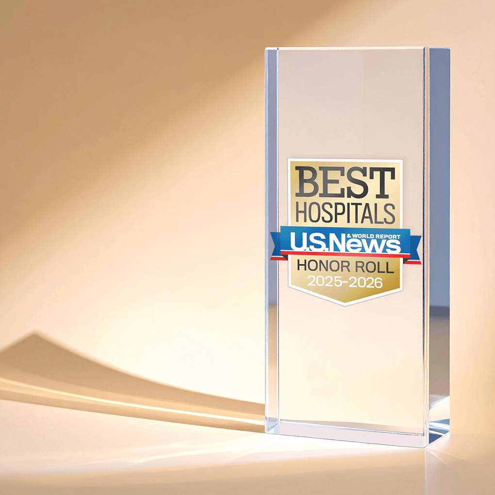 Ambient light shines on a glass tabletop trophy with a U.S. News badge reading “Best Hospitals Honor Roll 2025-2026.”